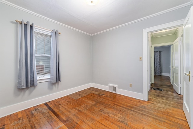 unfurnished room featuring ornamental molding and hardwood / wood-style floors