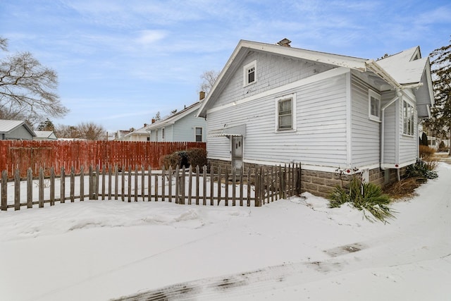 view of snow covered back of property