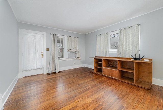 unfurnished living room featuring hardwood / wood-style flooring, crown molding, and cooling unit