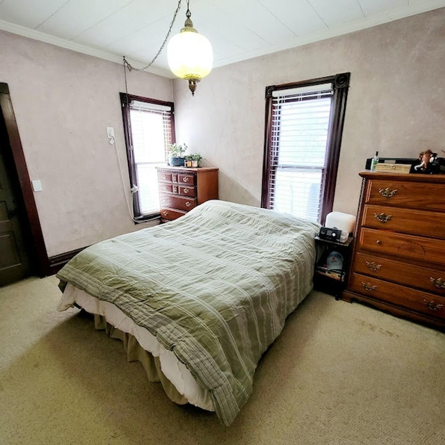 bedroom featuring crown molding and light colored carpet