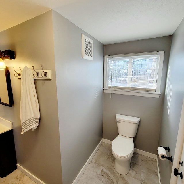 bathroom featuring vanity, toilet, and a textured ceiling