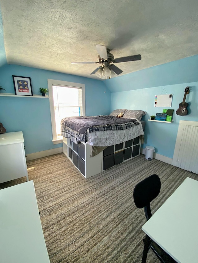 carpeted bedroom featuring vaulted ceiling, ceiling fan, and a textured ceiling