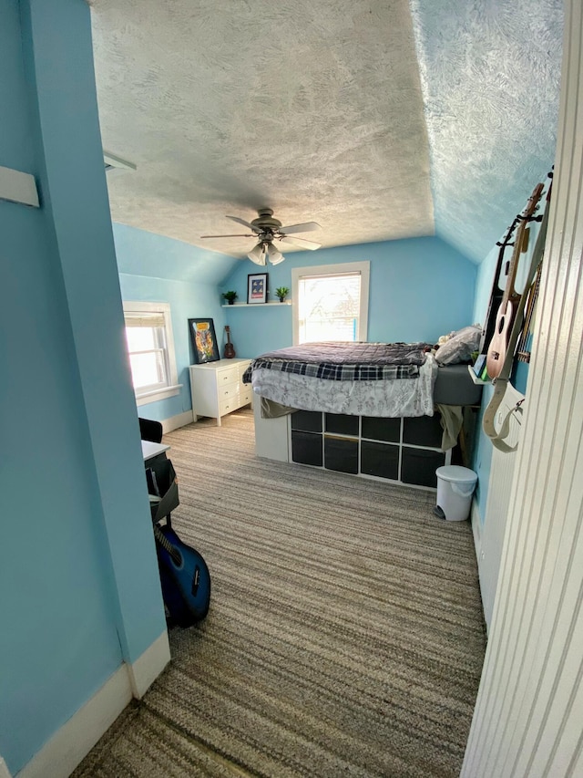 carpeted bedroom featuring multiple windows, ceiling fan, lofted ceiling, and a textured ceiling