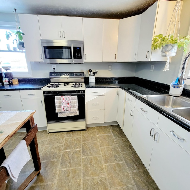 kitchen featuring white cabinetry, sink, and range with gas stovetop