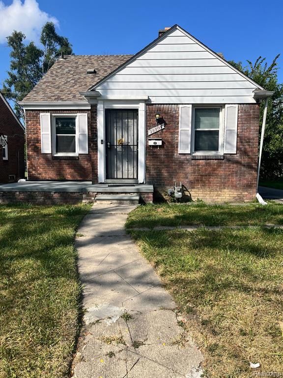 bungalow-style home with a front lawn