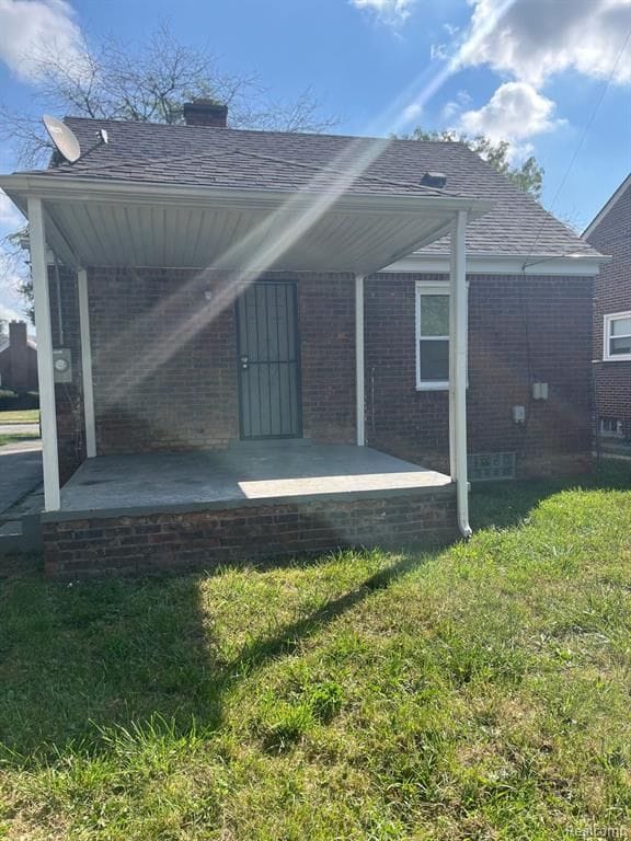 back of property with a patio and a lawn