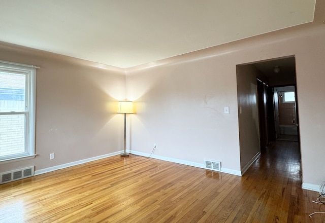 spare room with wood-type flooring and a wealth of natural light