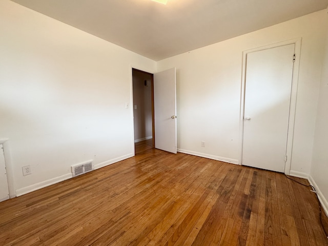 unfurnished bedroom with hardwood / wood-style flooring