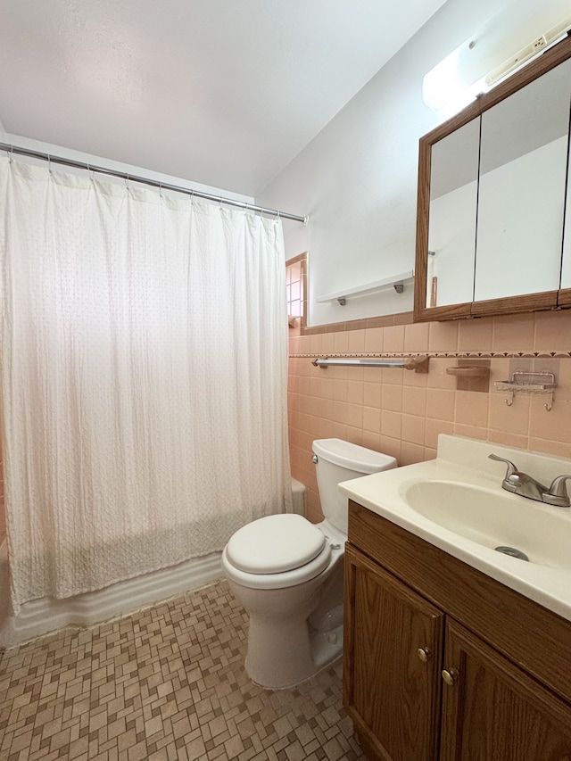 full bathroom with shower / bathtub combination with curtain, vanity, toilet, and tile walls