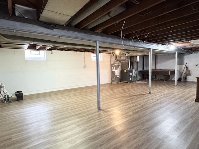 basement featuring hardwood / wood-style flooring and gas water heater