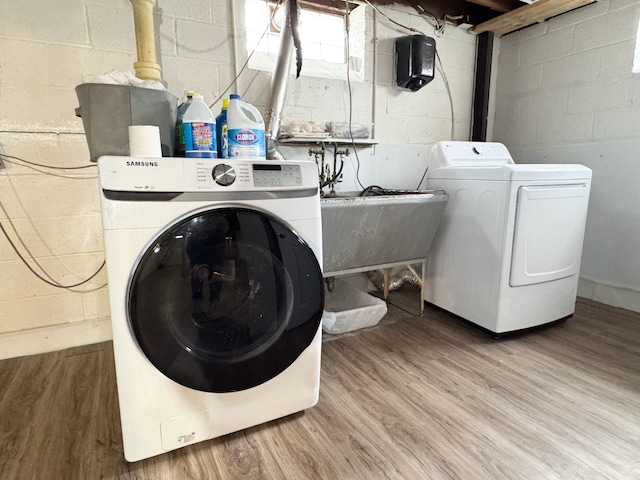 laundry room with washing machine and clothes dryer and wood-type flooring