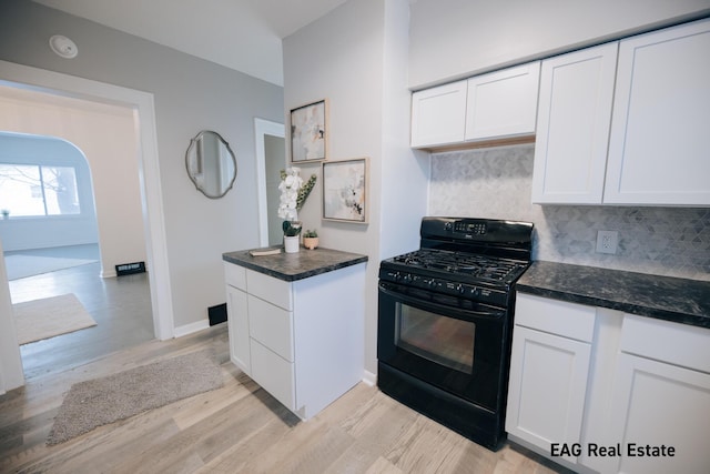 kitchen featuring decorative backsplash, light hardwood / wood-style flooring, white cabinets, and black gas range