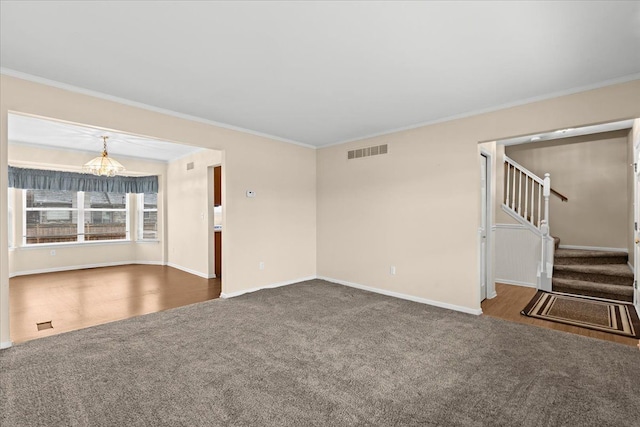 unfurnished living room with crown molding, a chandelier, and dark carpet