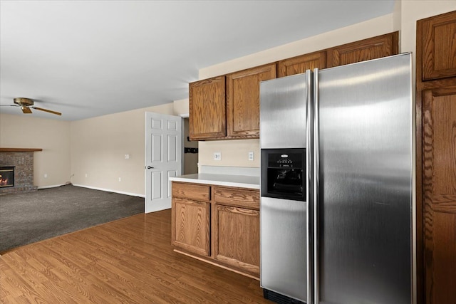 kitchen with dark wood-type flooring, ceiling fan, and stainless steel refrigerator with ice dispenser