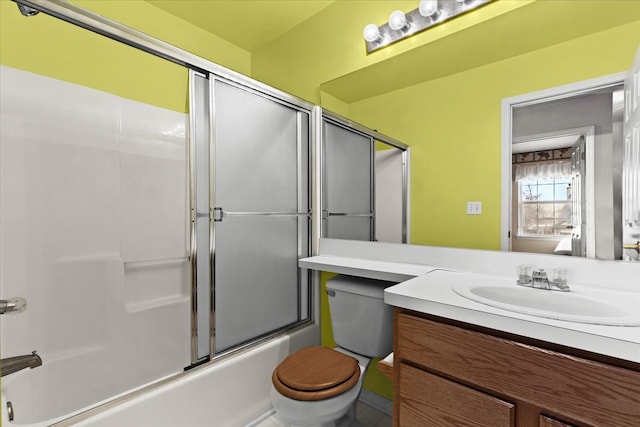 full bathroom featuring vanity, bath / shower combo with glass door, and toilet