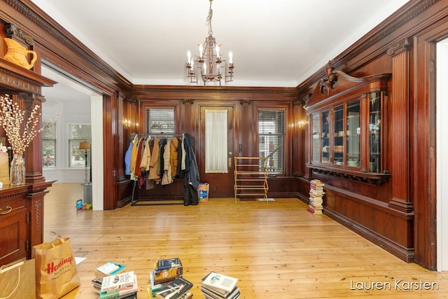 interior space with a wealth of natural light, a chandelier, and light hardwood / wood-style flooring