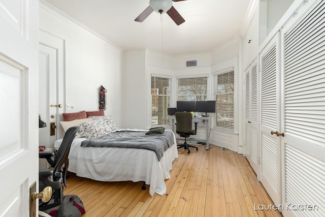 bedroom with ceiling fan, ornamental molding, and light hardwood / wood-style flooring