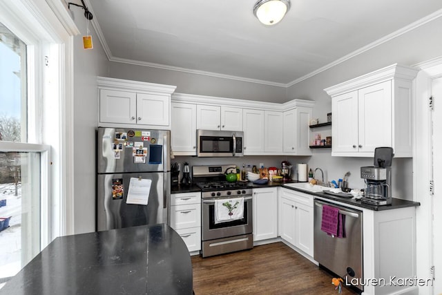 kitchen featuring sink, white cabinets, ornamental molding, stainless steel appliances, and dark wood-type flooring