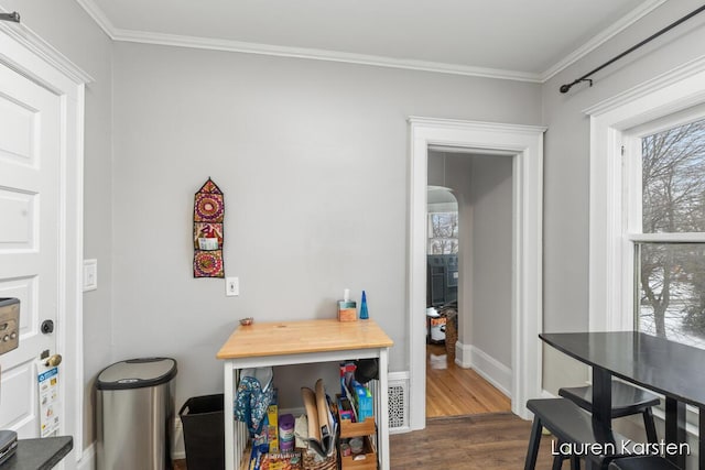 dining area featuring ornamental molding and dark hardwood / wood-style flooring