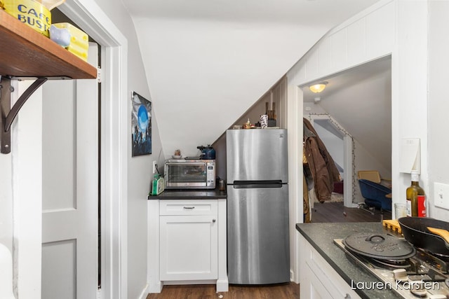 kitchen with white cabinets, gas stovetop, stainless steel fridge, and dark hardwood / wood-style flooring