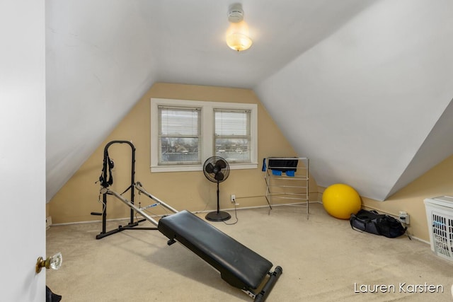 exercise area with light colored carpet and vaulted ceiling