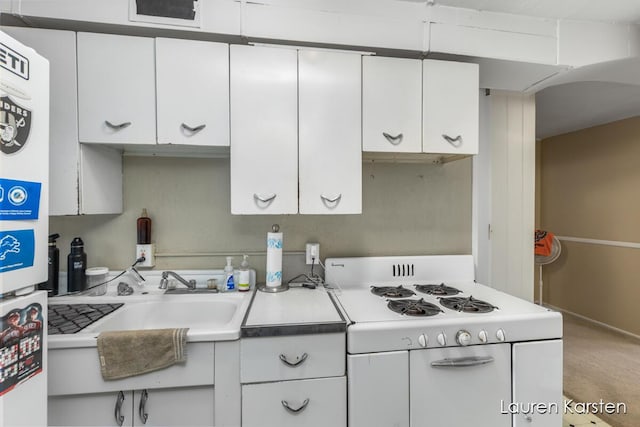 kitchen featuring white gas range, sink, and white cabinets