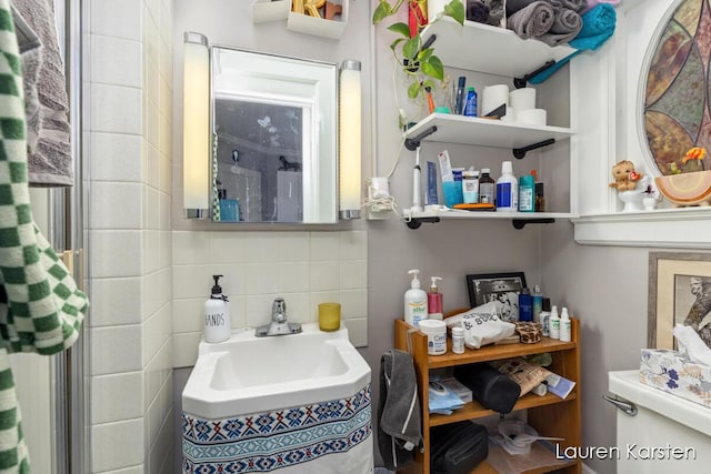 bathroom featuring tasteful backsplash, sink, and toilet