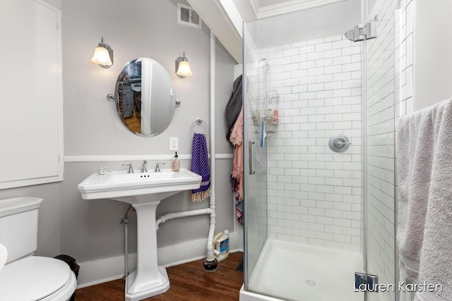 bathroom featuring hardwood / wood-style flooring, toilet, and walk in shower