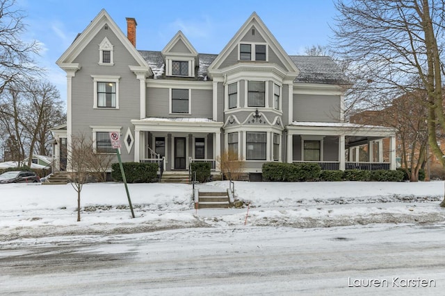 victorian-style house featuring covered porch and a chimney