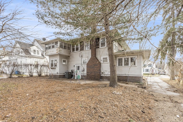 rear view of property featuring cooling unit, a patio, and a sunroom