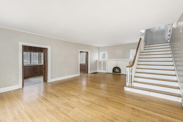 unfurnished living room with a fireplace and light wood-type flooring