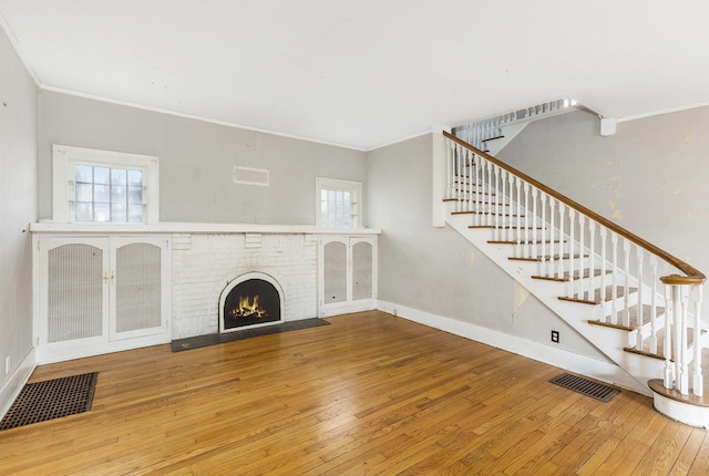 unfurnished living room featuring ornamental molding, hardwood / wood-style floors, and a wealth of natural light