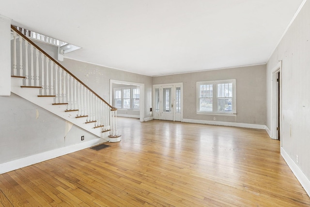 unfurnished living room featuring crown molding and light hardwood / wood-style floors