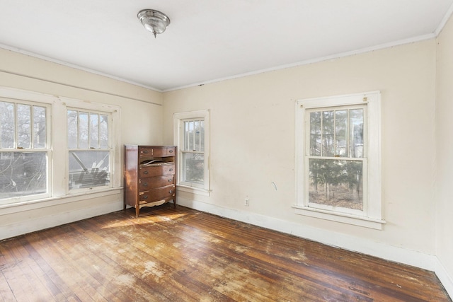 unfurnished room featuring dark hardwood / wood-style flooring, crown molding, and plenty of natural light