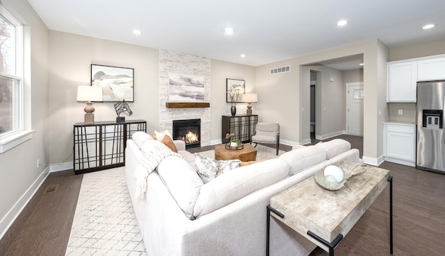 5090 Crandall Rd, Howell, MI 48855 - living area with dark wood-type flooring, a large fireplace, baseboards, recessed lighting, and healthy amount of natural light