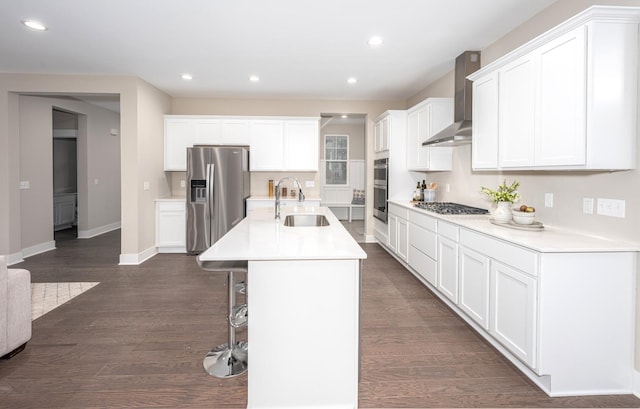5090 Crandall Rd, Howell, MI 48855 - kitchen featuring stainless steel appliances, wall chimney exhaust hood, a sink, a breakfast bar, and dark wood-style floors
