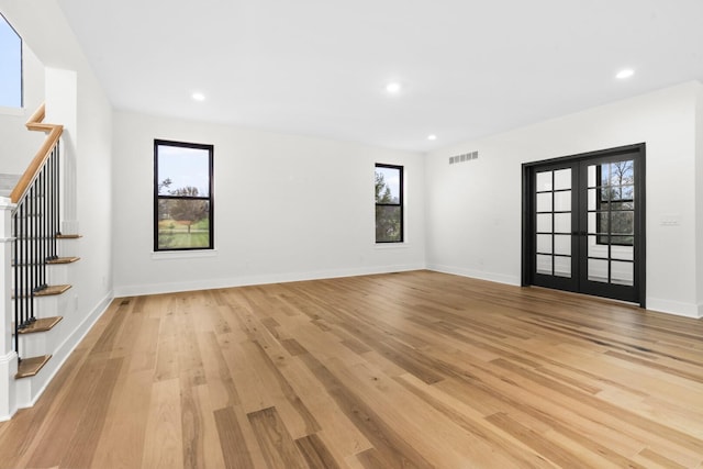 8200 Pine Ridge Ct, Northville, MI 48168 - unfurnished living room with stairs, french doors, light wood-style floors, plenty of natural light, and recessed lighting