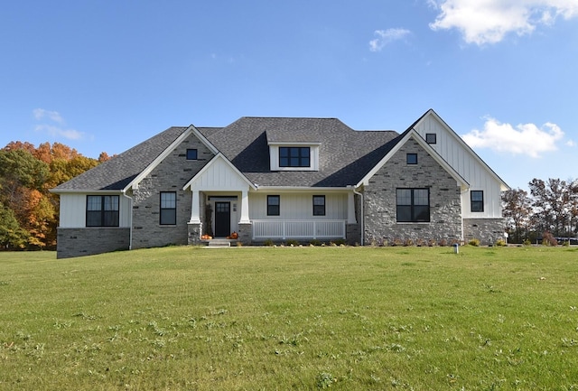 2735 Blue Bird Ln, Highland, MI 48357 - view of front of property with board and batten siding, a front yard, covered porch, and roof with shingles