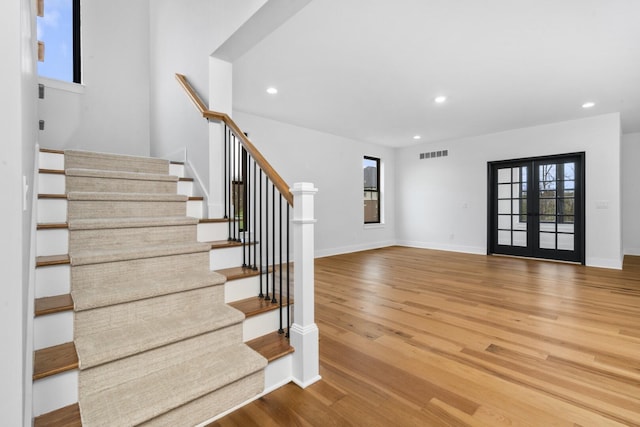 2735 Blue Bird Ln, Highland, MI 48357 - stairway with recessed lighting, wood finished floors, baseboards, and french doors