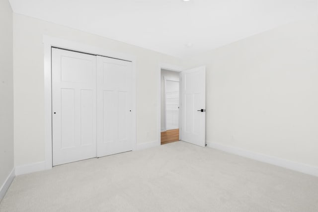 2735 Blue Bird Ln, Highland, MI 48357 - unfurnished bedroom featuring carpet flooring, baseboards, and a closet