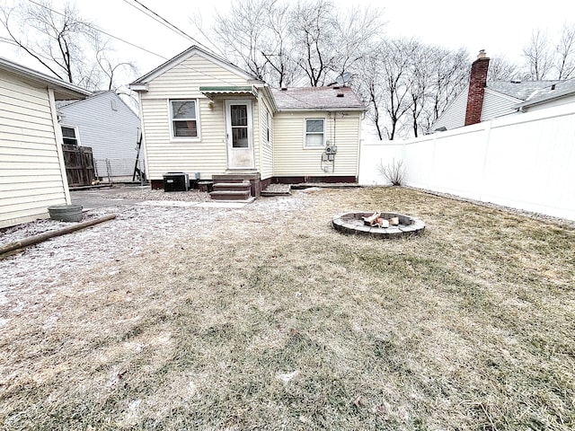 back of property with central AC and an outdoor fire pit