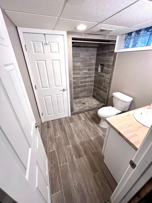 bathroom featuring vanity, toilet, and a tile shower