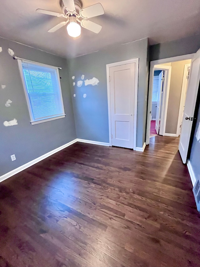 unfurnished bedroom with dark wood-type flooring and ceiling fan