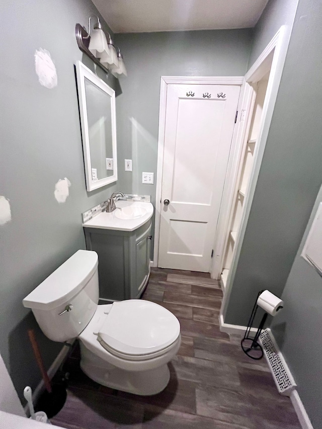 bathroom with vanity, hardwood / wood-style floors, and toilet