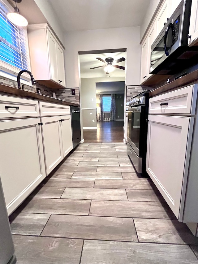 kitchen with backsplash, ceiling fan, appliances with stainless steel finishes, and white cabinets