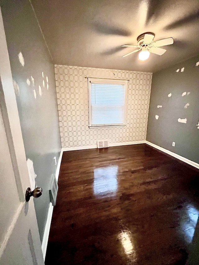 unfurnished room with dark hardwood / wood-style floors and ceiling fan