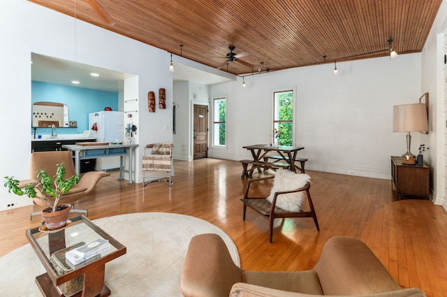 living room featuring sink, wood ceiling, light hardwood / wood-style flooring, and ceiling fan