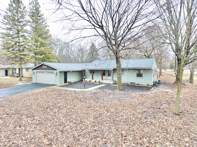 single story home with an attached garage, covered porch, and aphalt driveway