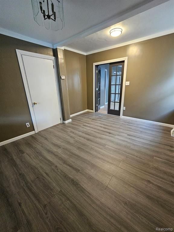 spare room featuring dark wood-type flooring, ornamental molding, and french doors