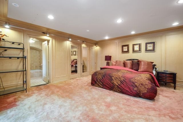 bedroom featuring a decorative wall, carpet flooring, recessed lighting, and ornamental molding